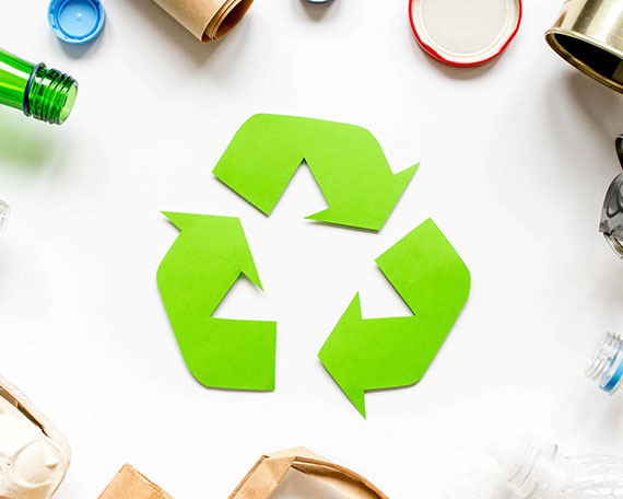 símbolo da reciclagem com materiais em volta